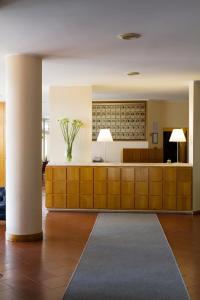 a lobby with a reception desk with a vase of flowers at Hotel dei Duchi in Spoleto