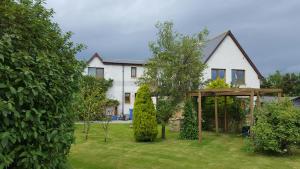 a house with a garden with a gazebo at Canterra Cottage in Tain