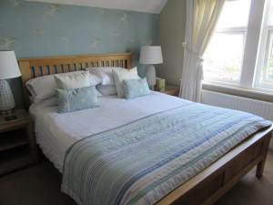 a bedroom with a large bed with two lamps and a window at The Langtons Bed & Breakfast in Eastbourne