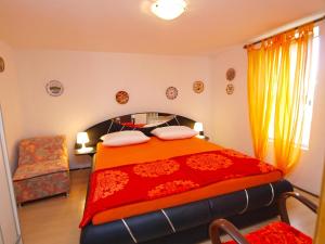 a bedroom with a large bed with an orange blanket at Apartments Milica 1391 in Banjole