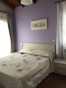 1 dormitorio con cama y pared púrpura en Il Tiglio en Viagrande
