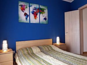 a bedroom with a bed with a blue wall at Taormina For You in Taormina