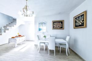 - une salle à manger blanche avec une table et des chaises blanches dans l'établissement Isola Antica, à SantʼAntìoco