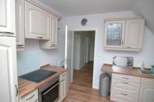 a kitchen with white cabinets and a counter top at Ferienwohnung Sonneneck in Scharzfeld