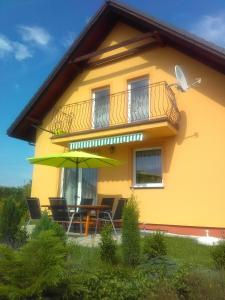 別爾斯科－比亞瓦的住宿－Apartment Helena，黄色的房子,配有桌子和雨伞