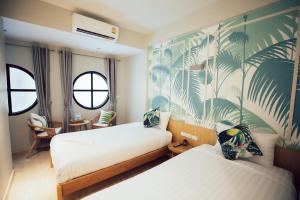 um quarto com 2 camas e um papel de parede tropical em J's Cafe and Poshtel em Chiang Mai