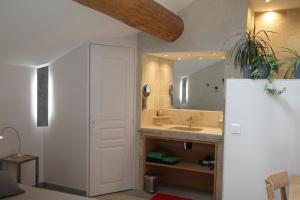 uma casa de banho com um lavatório e um espelho em L'atelier B&B em Bédoin
