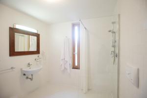 a white bathroom with a sink and a shower at Sopra il Limoneto in Cetara