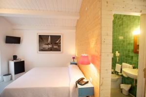 a bedroom with a bed and a bathroom with a sink at Sopra il Limoneto in Cetara