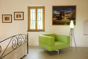 a green chair in a room with a painting at Sopra il Limoneto in Cetara
