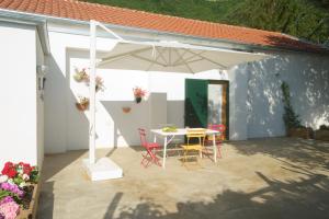 a patio with a table and a white umbrella at Sopra il Limoneto in Cetara
