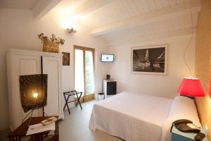 a bedroom with a white bed and a television at Sopra il Limoneto in Cetara