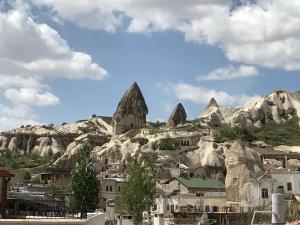 a group of buildings on a mountain with rocks at Osmanbey Cave House in Goreme