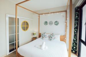 1 dormitorio con cama con dosel y sábanas blancas en J's Cafe and Poshtel en Chiang Mai
