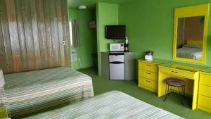 Habitación con 2 camas, escritorio y espejo. en Caribbean Motel en Wildwood Crest