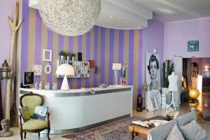 a dressing room with purple walls and a couch and a table at Hotel Roma in Grottammare