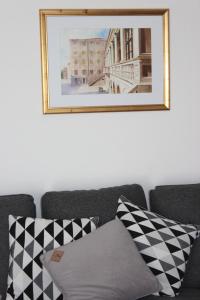 ein Bild hängt an einer Wand über einer Couch mit Kissen in der Unterkunft Apartment Floral in Brodarica