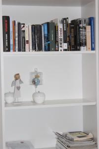 ein Bücherregal mit Büchern und einer Puppe darauf in der Unterkunft Apartment Floral in Brodarica
