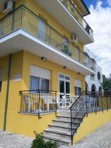 Edificio amarillo con escaleras y balcón en Albergo Acapulco, en Bellaria-Igea Marina