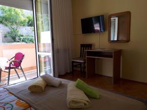 een slaapkamer met 2 handdoeken op een bed en een bureau bij Guest house Maria Rosa in Rab