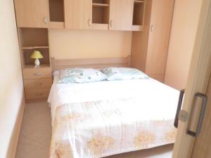 una piccola camera da letto con un letto e una cassettiera di Apartmani Seršić a Baška