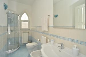 a white bathroom with a sink and a toilet at Villa al Porto in Ischia +18 photos