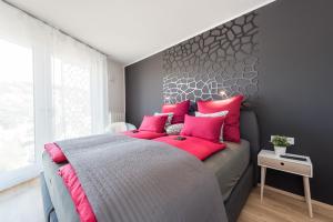 una camera da letto con un grande letto con cuscini rossi di V7 Boutique Appartements a Friburgo in Brisgovia