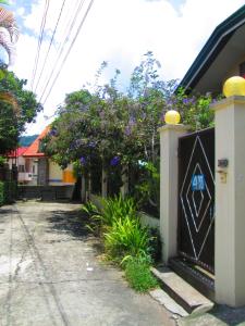 Una puerta a una casa con flores. en Small House - Baguio, en Baguio