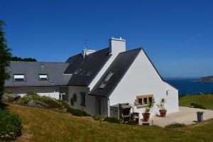 una casa blanca con techo negro en una colina en Kichen Ar Mor en Poullan-sur-Mer