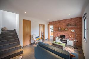 a living room with a couch and a brick wall at Casa do André (Casas do Capelo) in Fajã