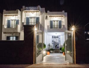 a large white building with a gate at night at Studios Antoniou in Skala