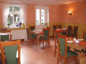 a dining room with tables and chairs and a window at Pension Ginko in Wernigerode