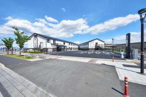 an empty parking lot in front of a building at Hotel Kan Raku Honjo Waseda Ekimae in Honjo