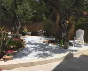 ルッファーノにあるNel Giardino di Isabelの木の庭と白い椅子