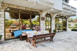 a table and a bench on a patio at Guest House Lukac in Bar