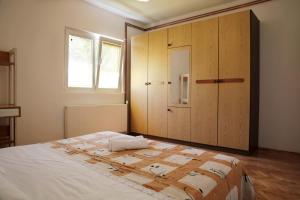 una camera con letto e armadietto in legno di Apartments Roko a Tisno (Stretto)