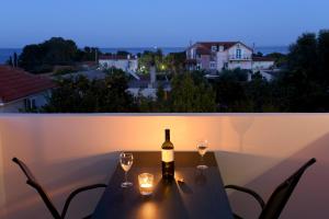 una bottiglia di vino seduta su un tavolo con bicchieri da vino di Natalie's Hotel a Skala di Cefalonia