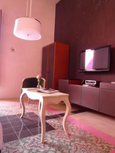 a living room with a tv and a lamp at Rosas & Xocolate Boutique Hotel+Spa in Mérida