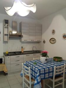 a kitchen with a table with a blue and white table cloth at Lentisco in Capoliveri