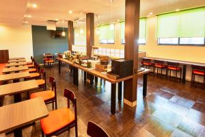 a dining room with tables and chairs in a restaurant at Hotel Kan Raku Honjo Waseda Ekimae in Honjo