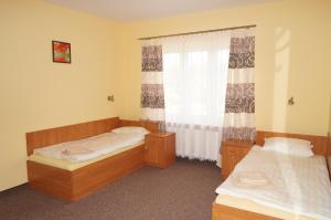 two beds in a small room with a window at Hotel-Restauracja-Bar Rudka in Ostrowiec Świętokrzyski