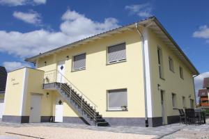 un edificio amarillo con una escalera lateral en Family Apartments, en Rust