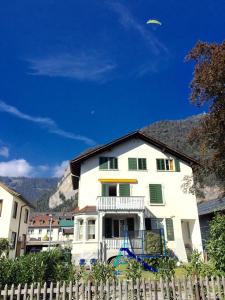 une maison blanche avec une clôture devant elle dans l'établissement Interlaken Marco Hostel, à Interlaken