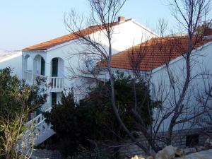 a white house with a red roof at Apartmani Jokić - family only in Pag