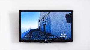 a television screen with a picture of a building at Studios Antoniou in Skala