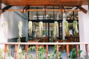 a restaurant with plants hanging from the ceiling at Boon Street Hostel in Bangkok