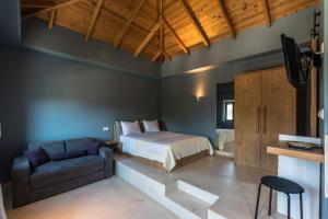 a bedroom with a bed and a couch and a tv at Anthelia in Skala Potamias +64 photos