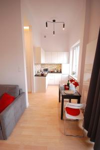 ワルシャワにあるNowy Apartament Wilczaのリビングルーム(ソファ、テーブル付)、キッチンが備わります。