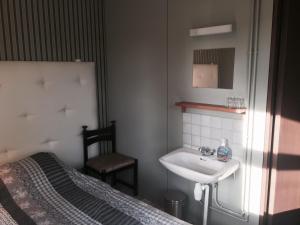 a bathroom with a sink and a bed at Kerihovi in Kerimäki