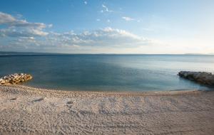 uma vista para uma praia com água e rochas em Seaside Luxury Suites em Podstrana